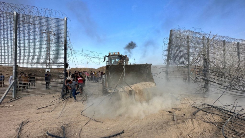 Digger smashing through occupation fence